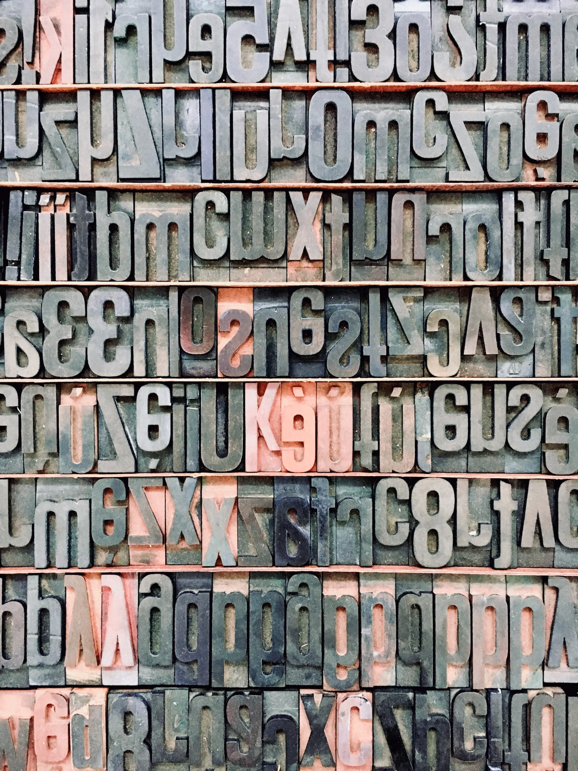 A set of letters in different typefaces on a wall.