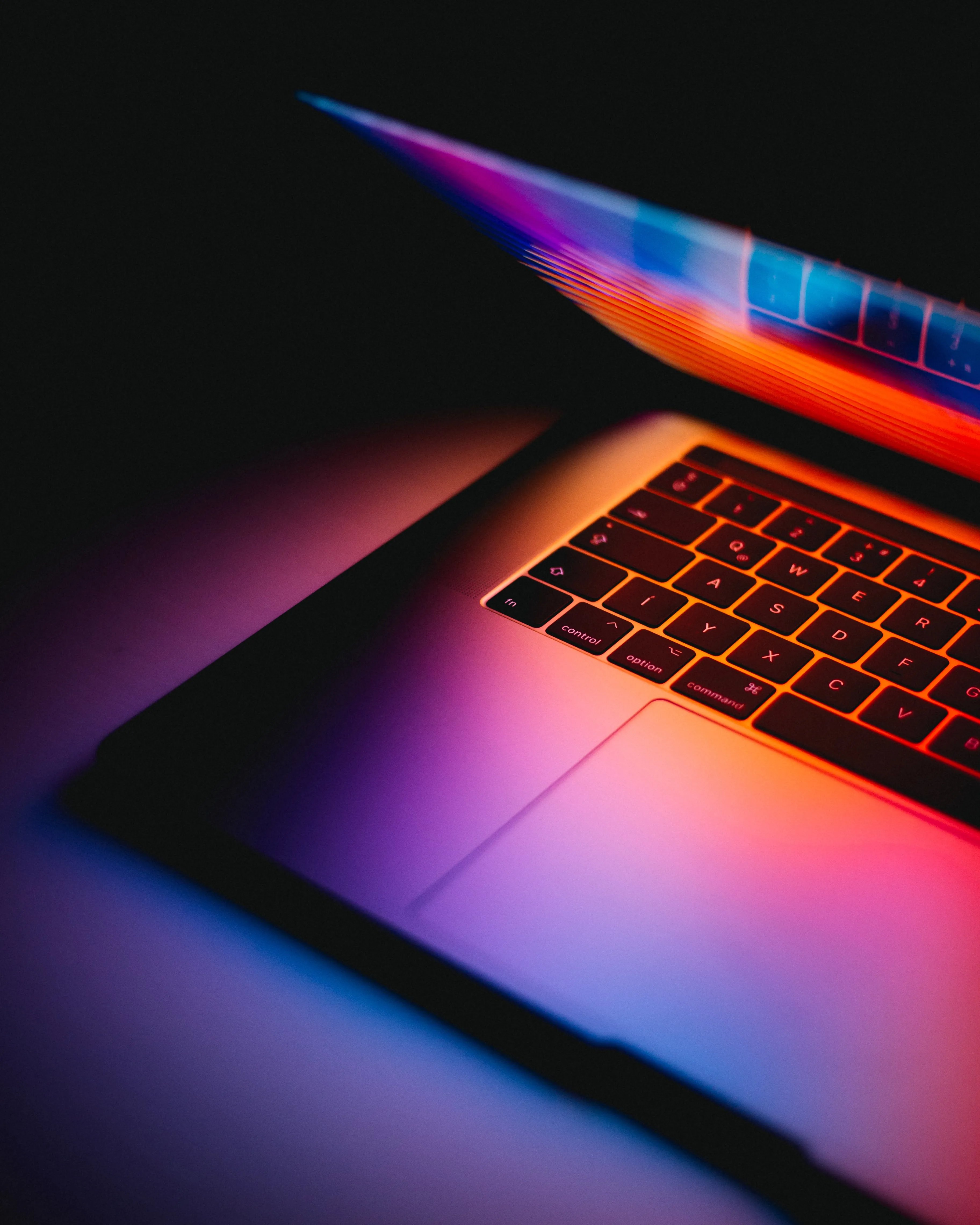 A Macbook Pro with coloured lighting