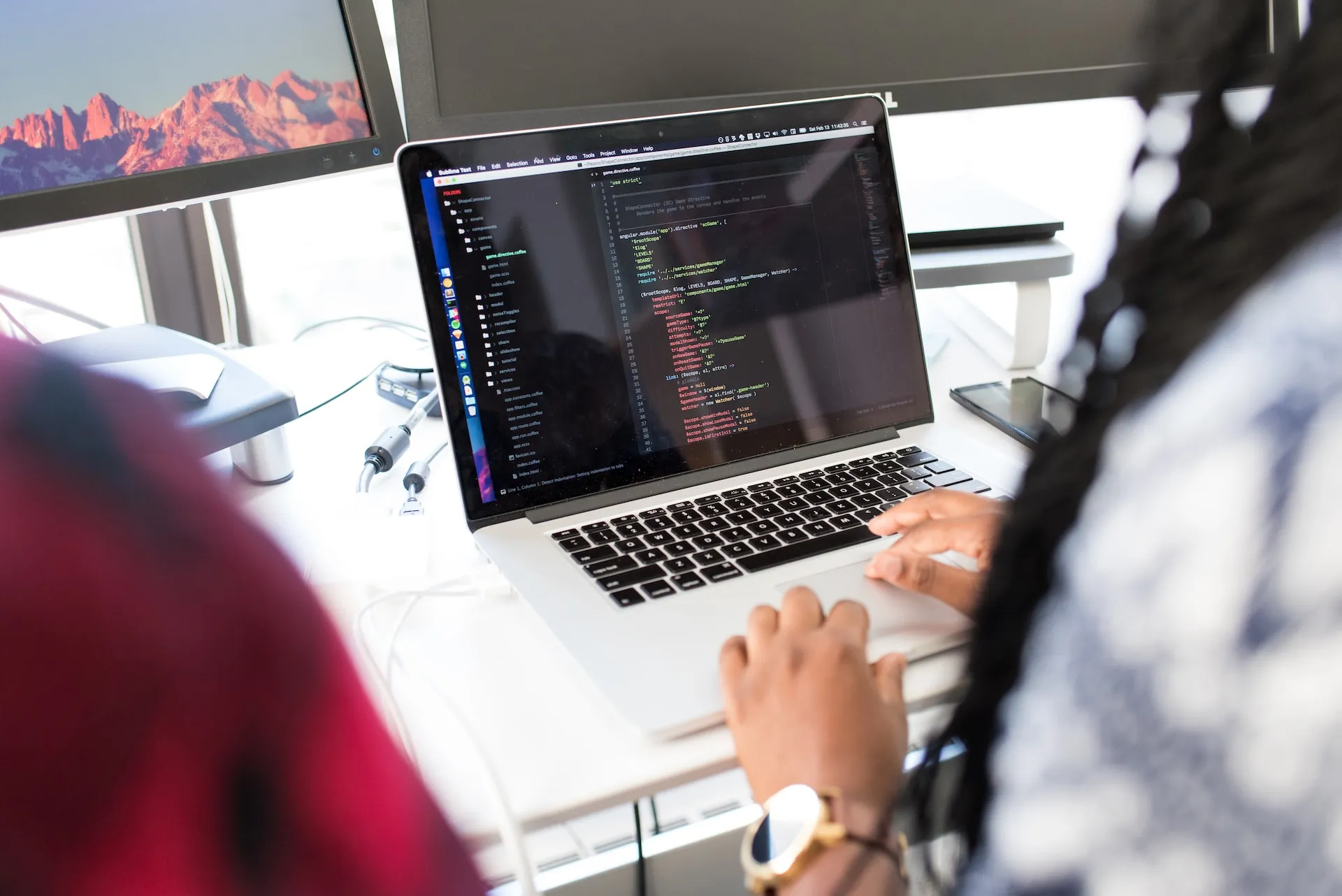 A software engineer editing code on a laptop.